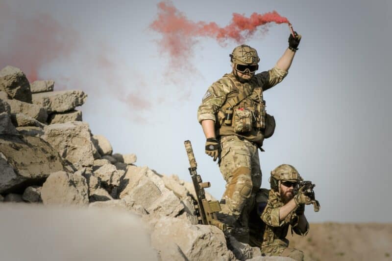 soldier using a red signaling flare